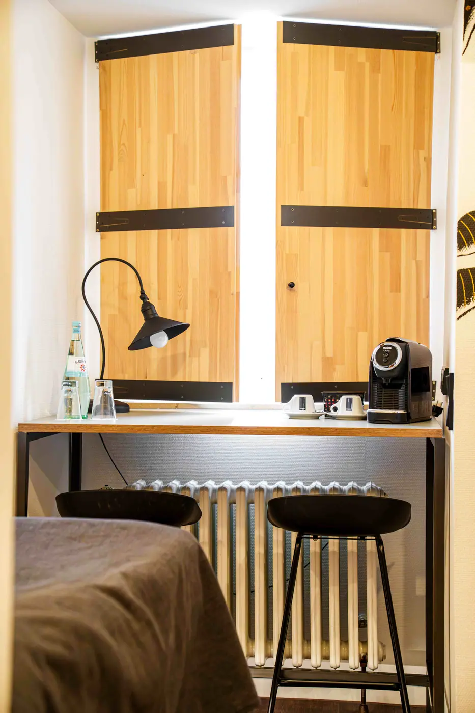 Fensterplatz mit Holzläden, Leuchte, Kaffeemaschine und Barhockern